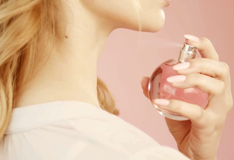 Girl applies a fragrance with a summer scent